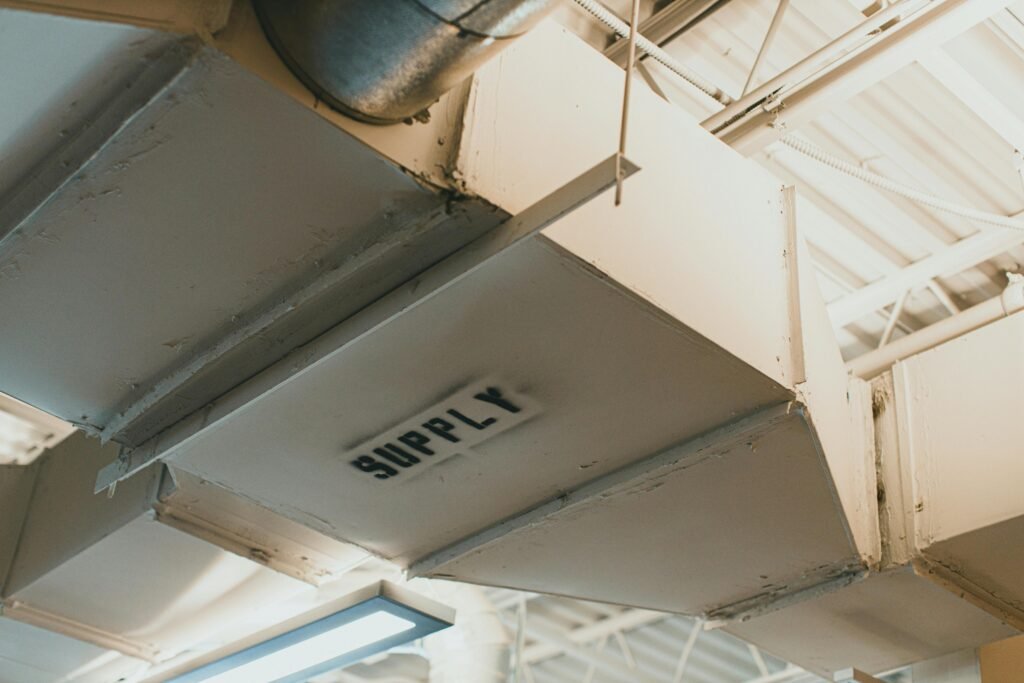 Close-up view of an air duct labeled 'SUPPLY' in an industrial setting.